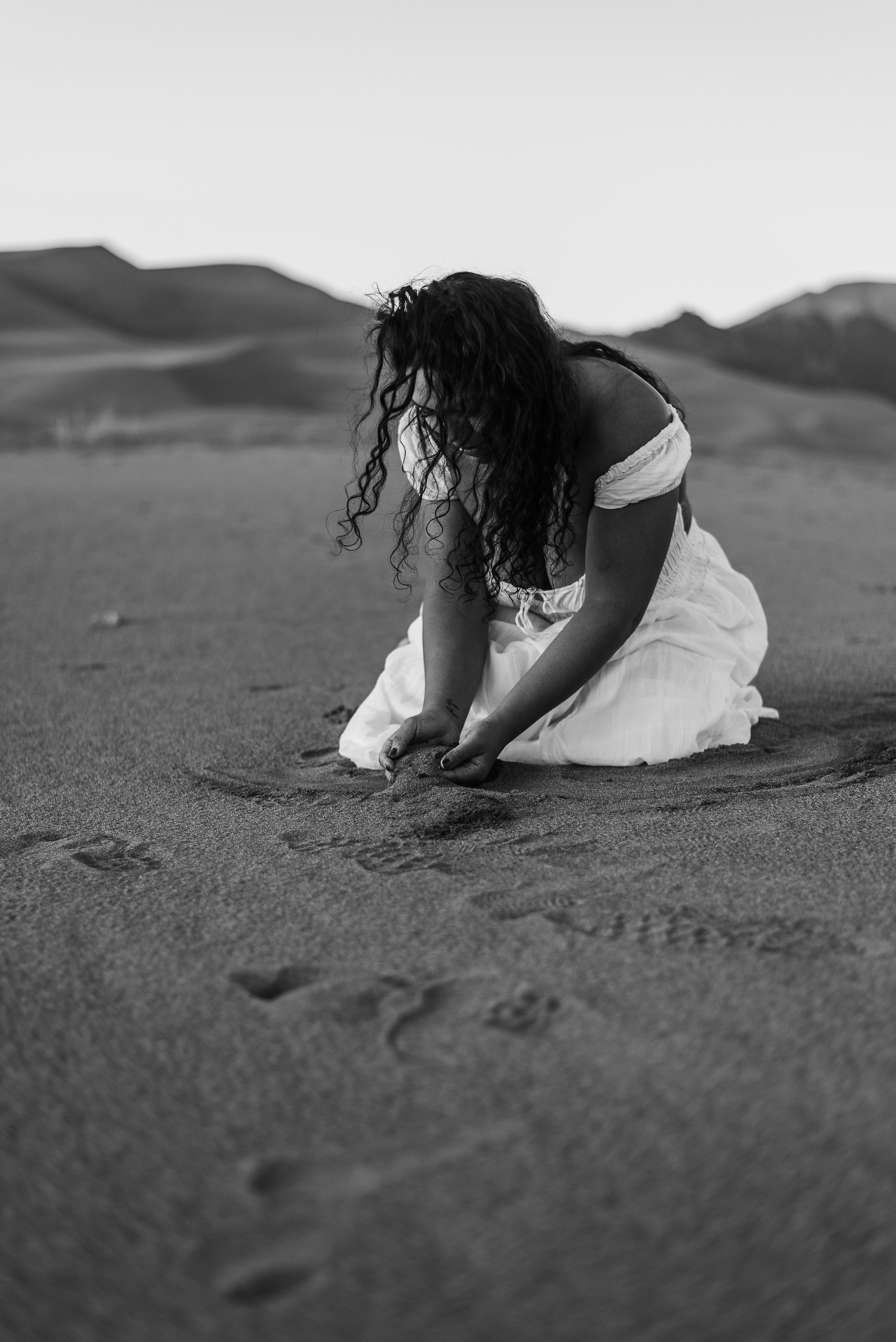 woman playing with sand near Pueblo, Colorado.