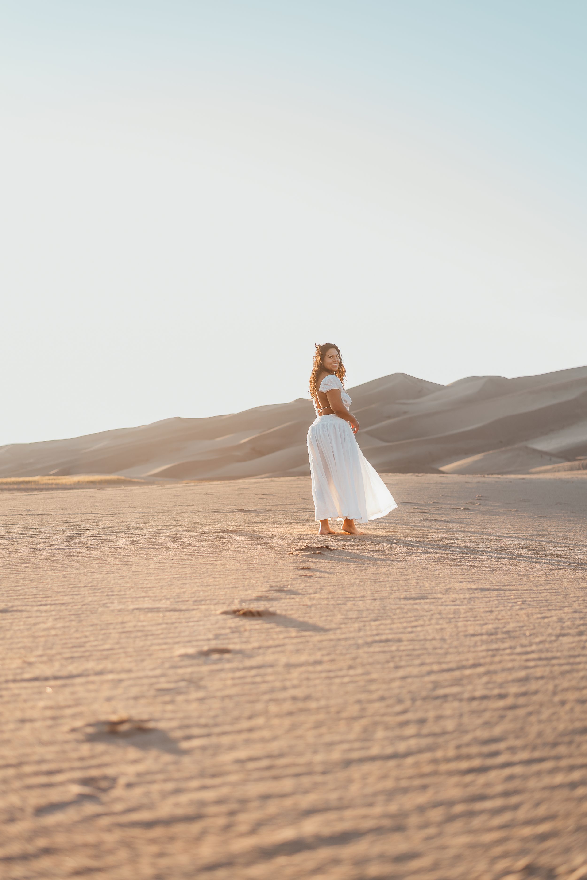 woman walking into the distance in the sand