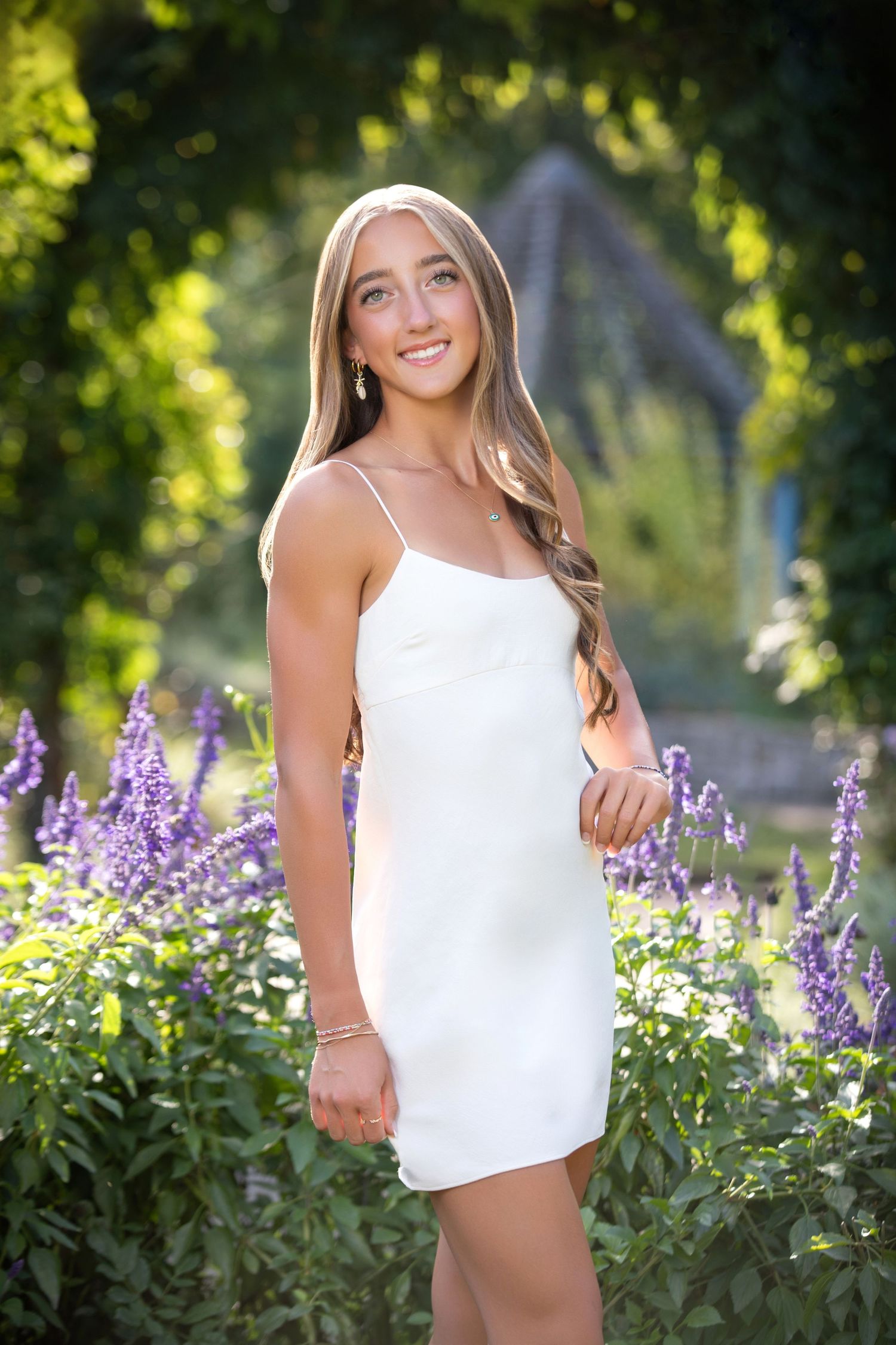 Olentangy Liberty senior portrait at Inniswood Gardens with purple flowers, white dress, and natural outdoor scenery.