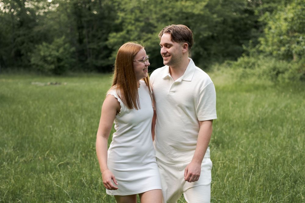 Jeunes amoureux profitant d'un coucher de soleil lors d'une séance couple en forêt.