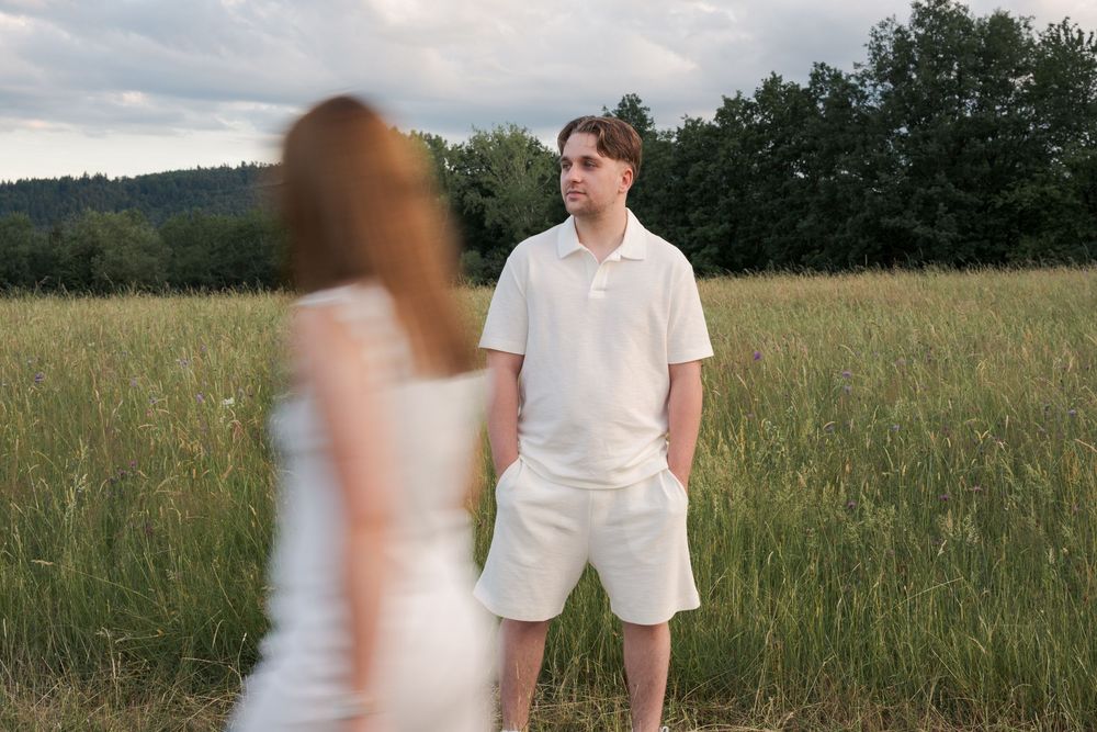 Photo romantique d'un jeune couple dans une prairie fleurie en forêt.