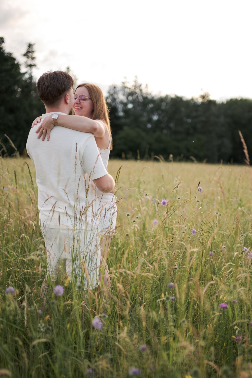 Couple habillé de blanc profitant d'une séance photo en pleine nature.