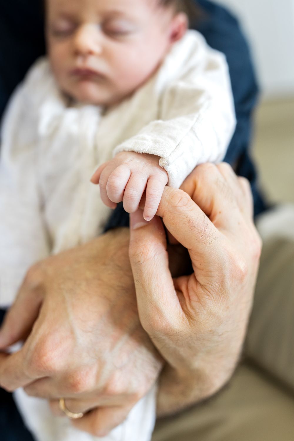 tiny baby fingers wrapped around adult finger