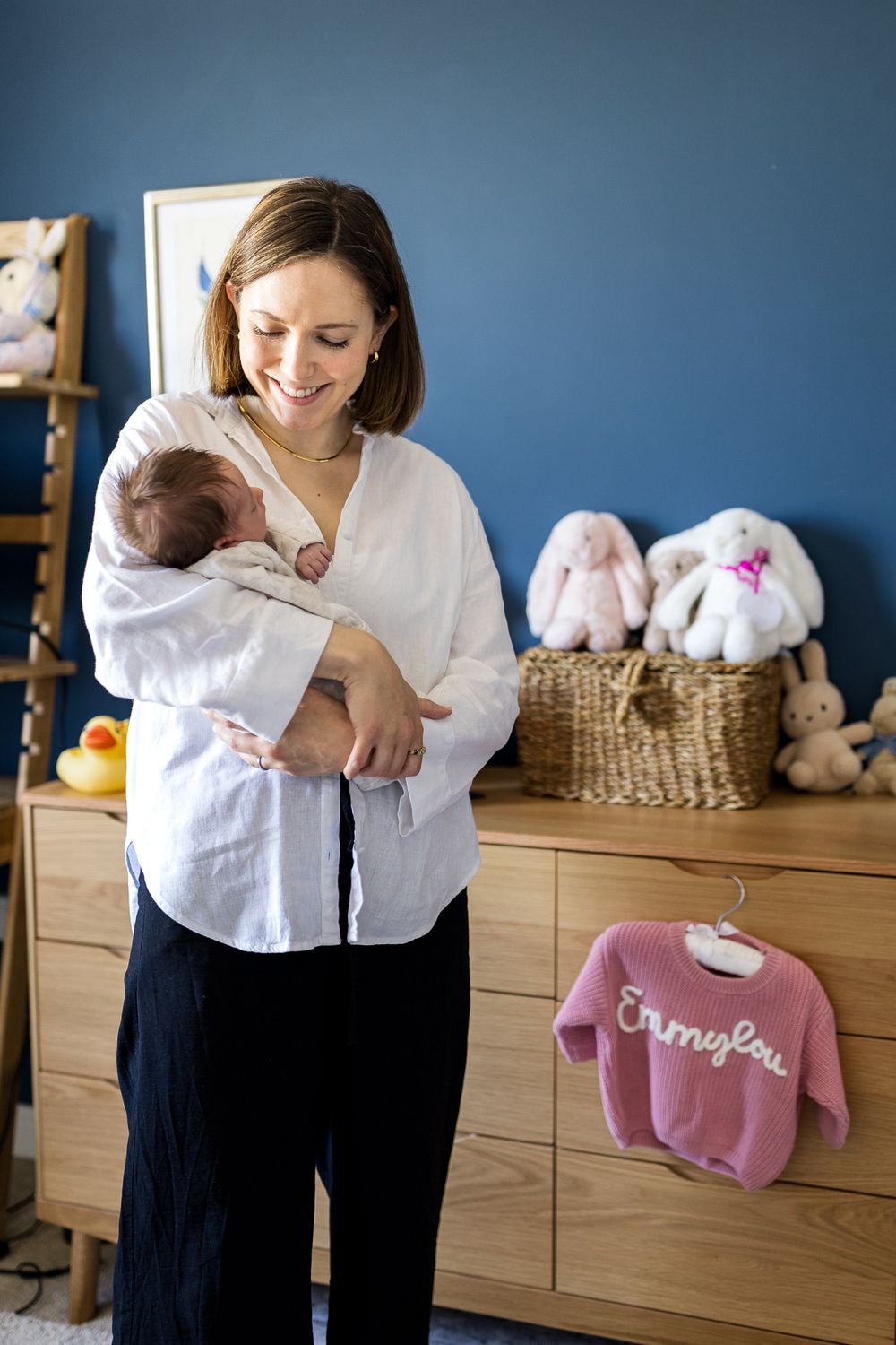 mum holding her baby daughter in arms in baby's nursery