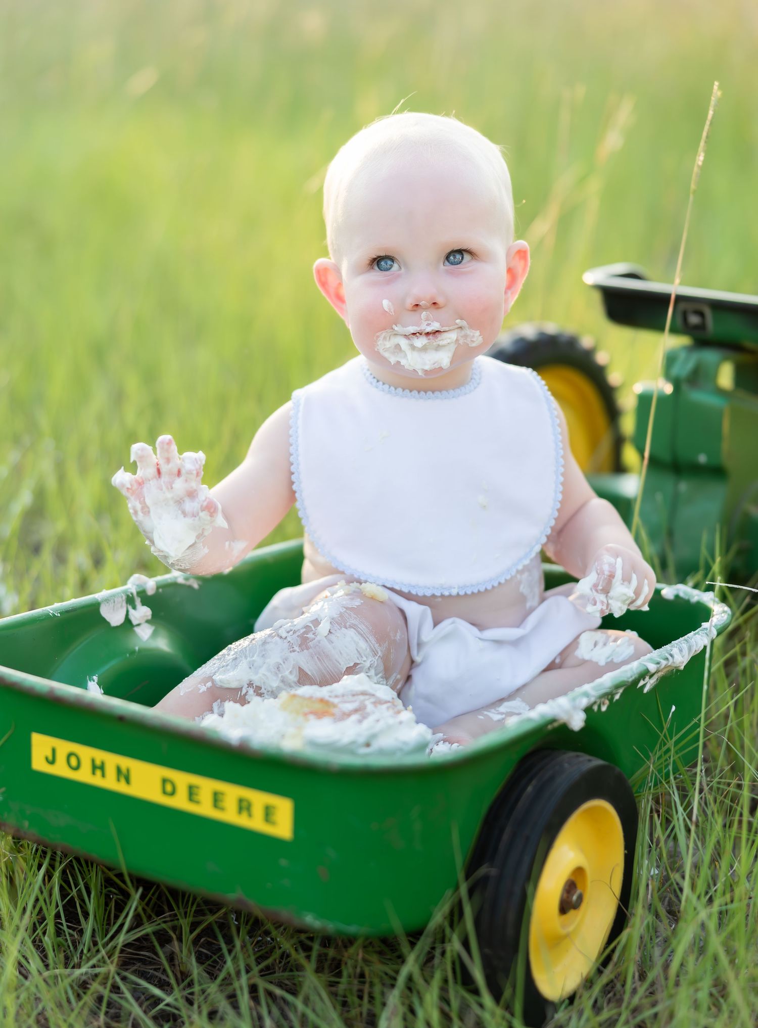 Baby girl sits on white blanket for cake smash. 1 year old milestone portraits Effingham County