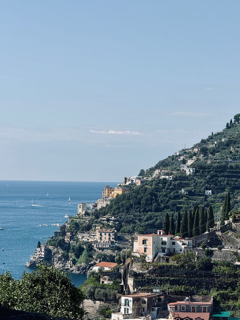 Aerial view of colorful hillside buildings cascading down to the blue Mediterranean Sea on the Amalfi Coast, Italy.