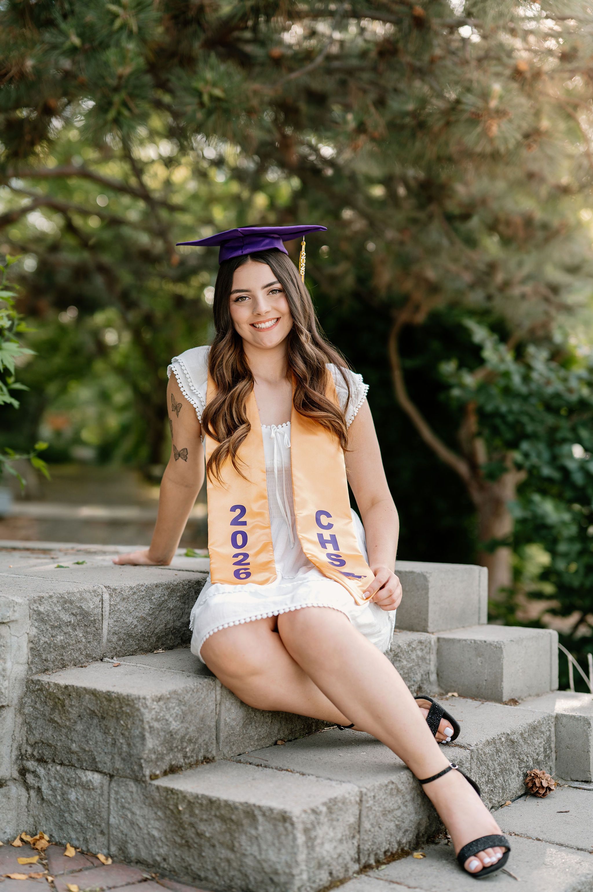 2026 senior with her cap and gown at WSU Demonstration Gardens in Tri-Cities, WA