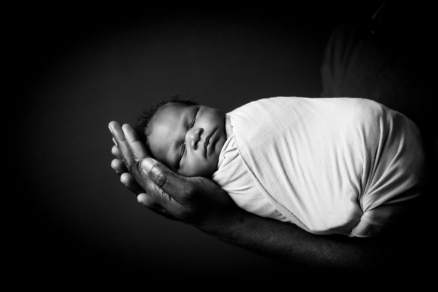 Artistic black and white newborn photography series with minimalist composition.