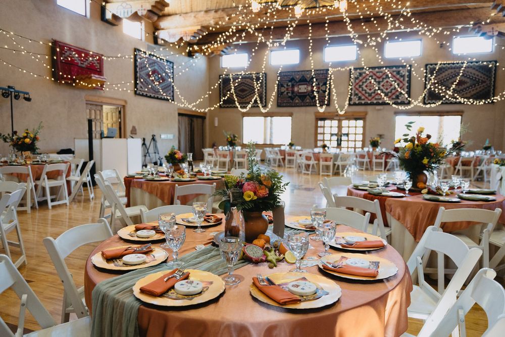 Elegant wedding reception hall with string lights, round tables, and warm terracotta table settings at Nature Pointe Venue