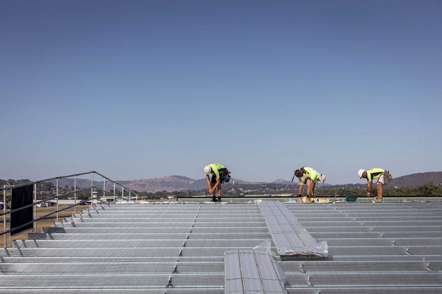 Roof Builders fixing roofing sheets onto a commercial building. Commercial Images by Albury Wodonga Commercial Photographer Jason Robins