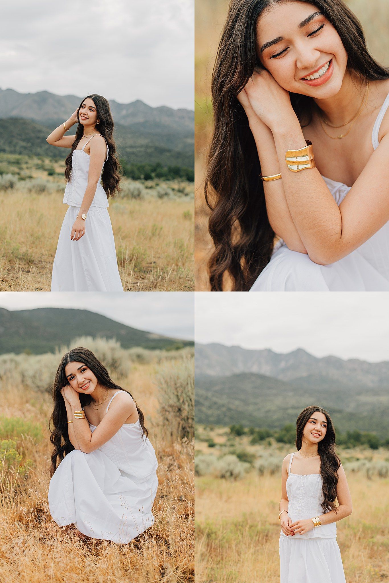 Young woman in white dress poses in mountain meadow with long wavy hair and gold bracelets, smiling joyfully.
