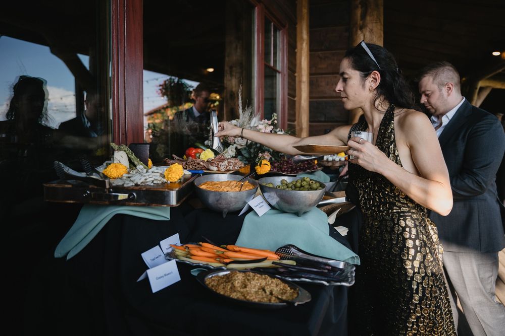 Guests serving themselves at an elegant buffet table with fresh vegetables and salads at a formal event.