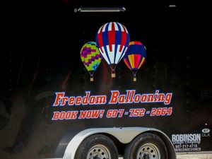Freedom Ballooning trailer sign with hot air balloons graphic and booking phone number 607-752-2664.