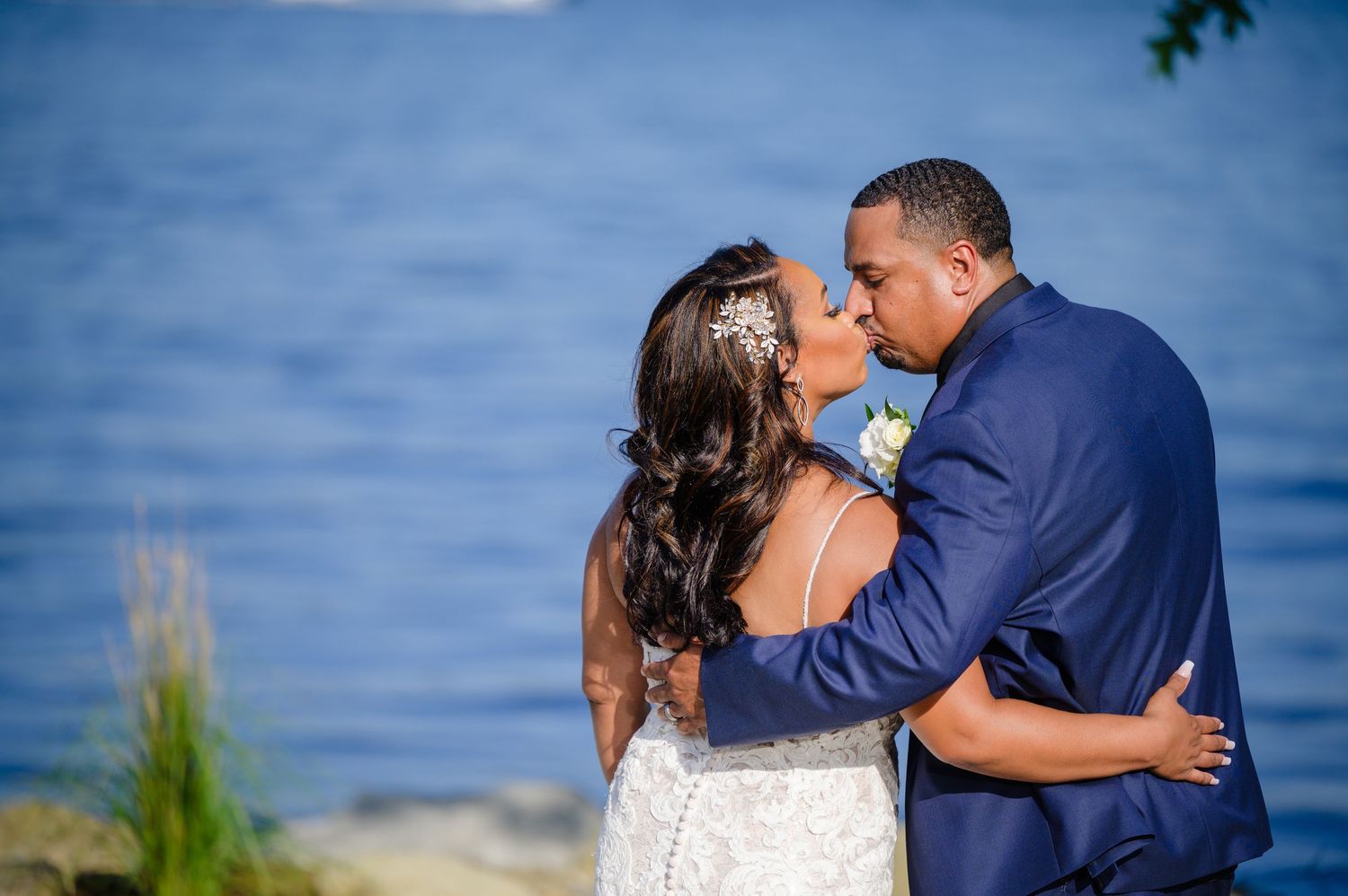Bride and Groom kissing in front of the lake at Tudor House at Mason's Cove on Portage Lakes in Akron Ohio after their wedding ceremony