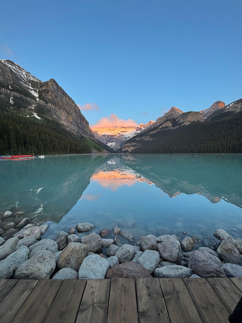 Stunning panoramic view of Lake Louise in Banff National Park with turquoise waters and mountain reflections at sunset.
