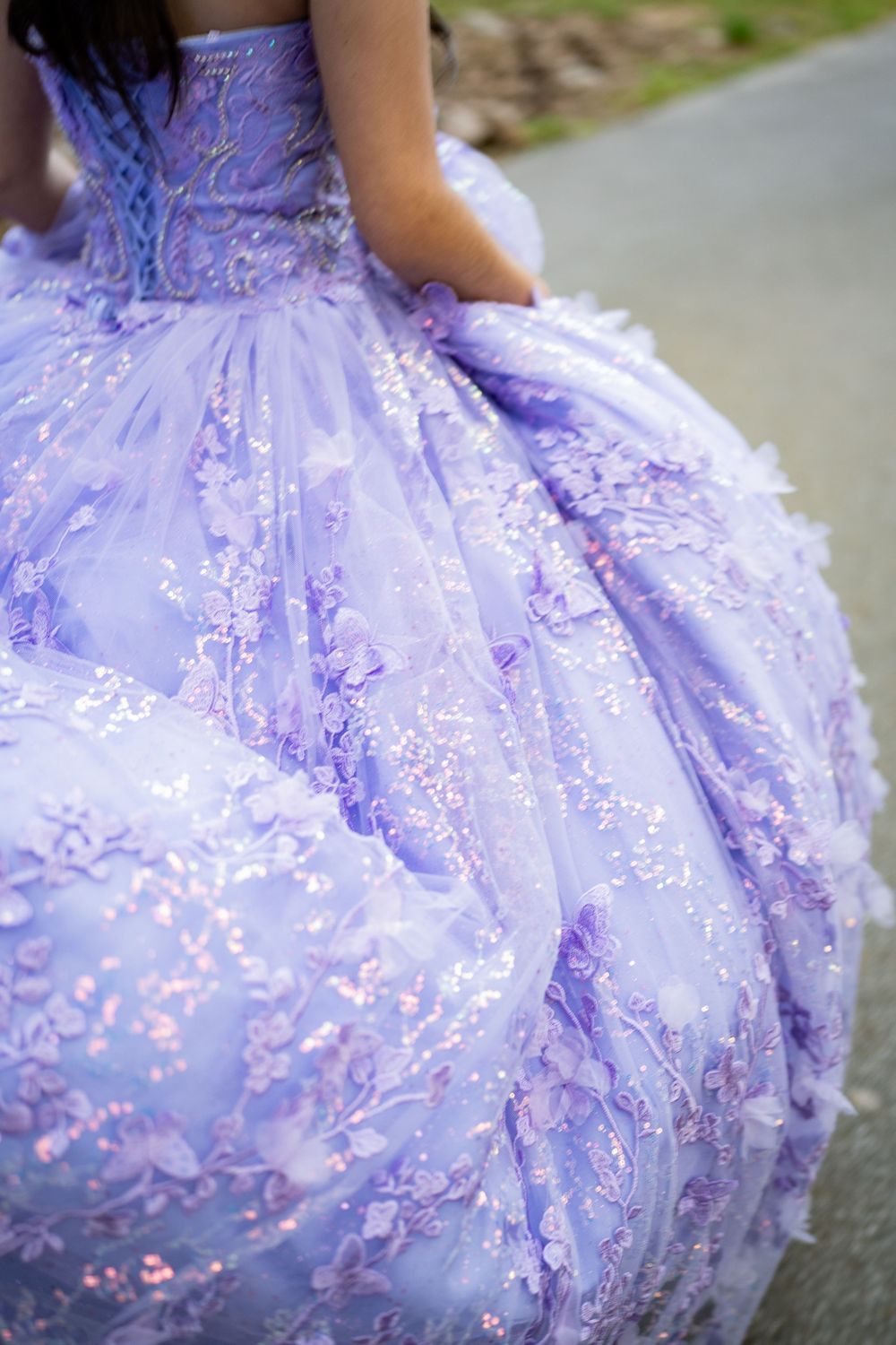 Lavender ball gown with floral lace embroidery and iridescent sequins, perfect for quinceañera or formal occasions.