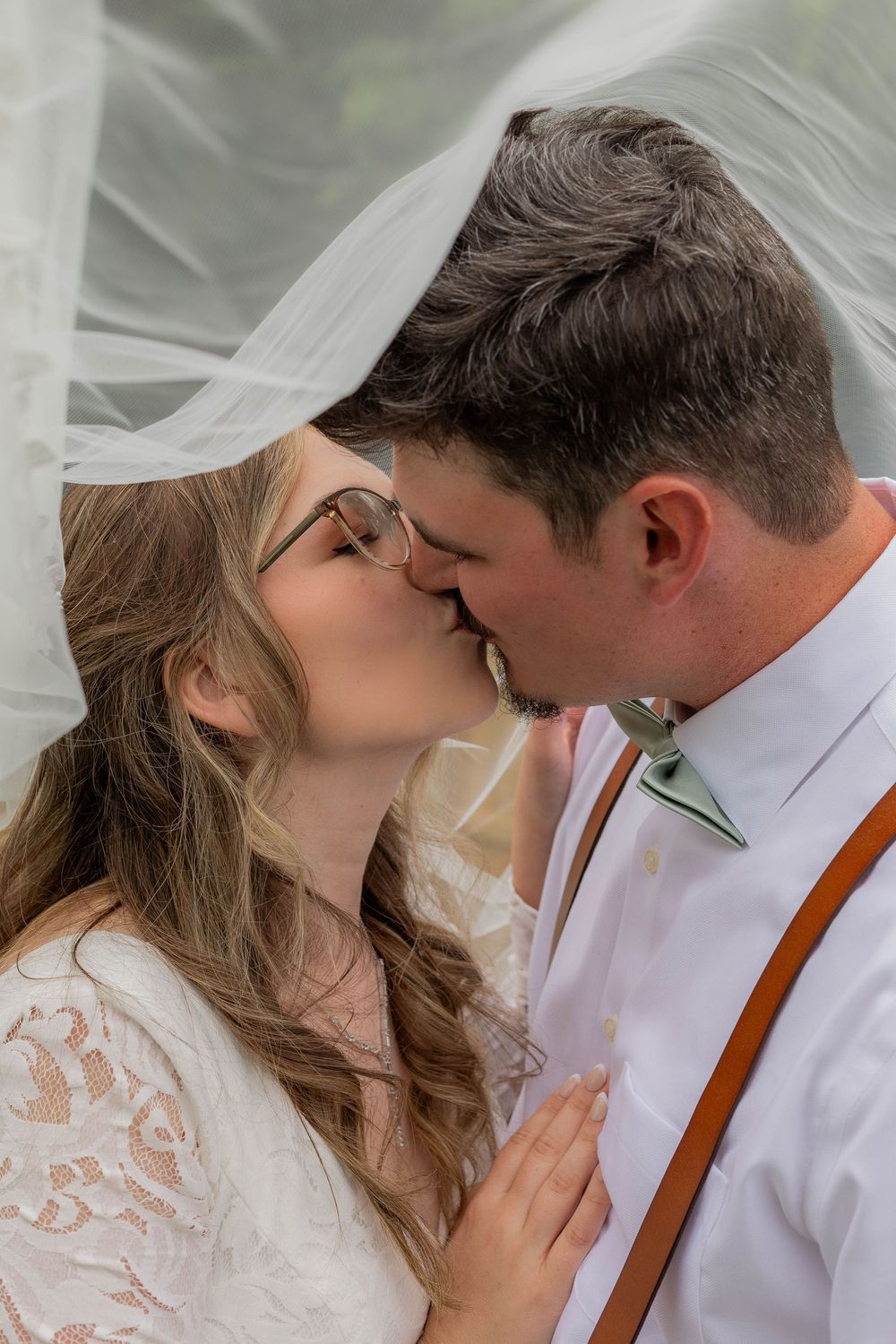 A romantic wedding kiss sequence showing five progressive moments between a couple in white attire and brown suspenders.