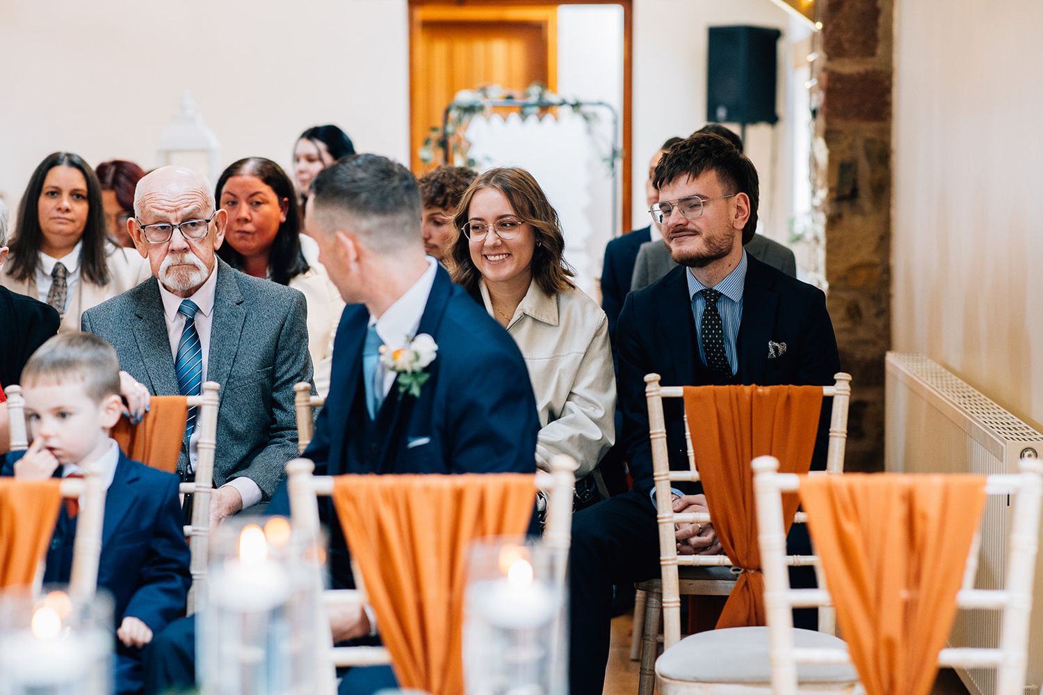 Wedding welcome sign for Matthew and Teresa on an ornate silver easel beside a wooden reception desk with a vase of autumn flowers.