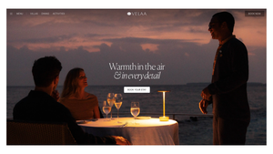 Romantic beachside dinner for two at sunset with a waiter serving wine at an elegantly lit table by the ocean.