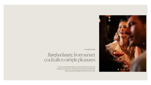 A woman laughs joyfully while holding a cocktail at a sunset luxury resort, embodying barefoot elegance.