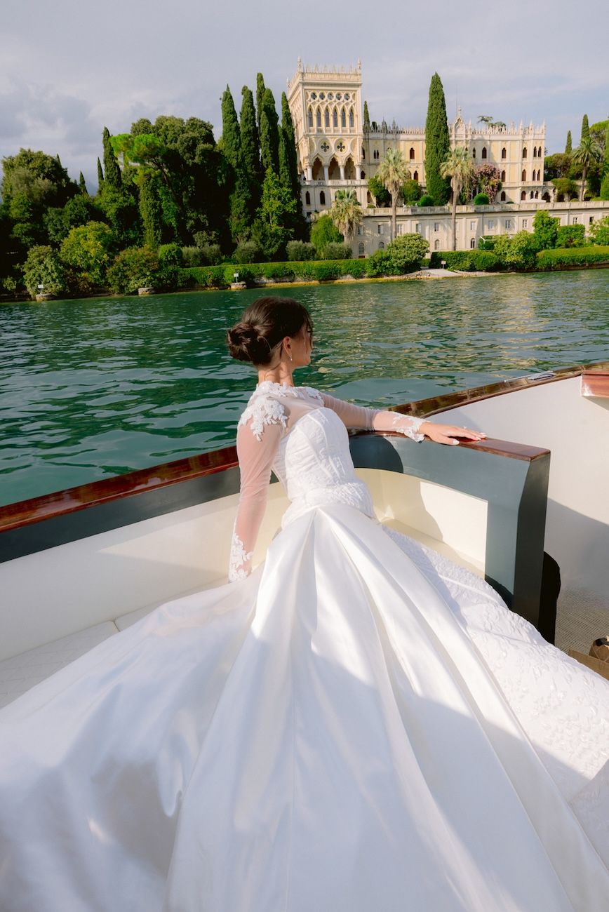 Bride on the boat looking at Isola del Garda on the way to Villa Bettoni for the wedding ceremony