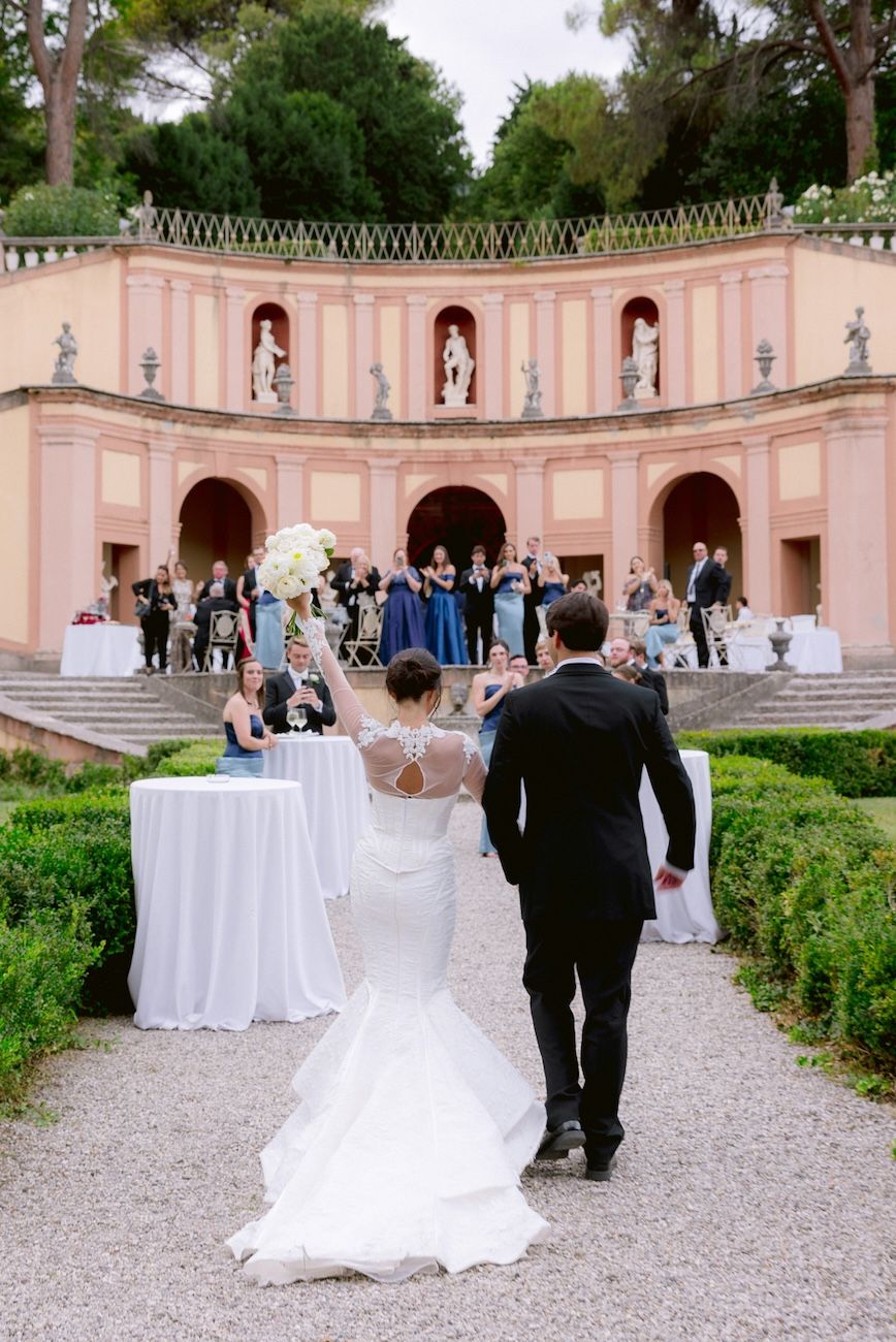 Bride and groom walking in the monumental garden of Villa Bettoni. Lake Garda. Italy.