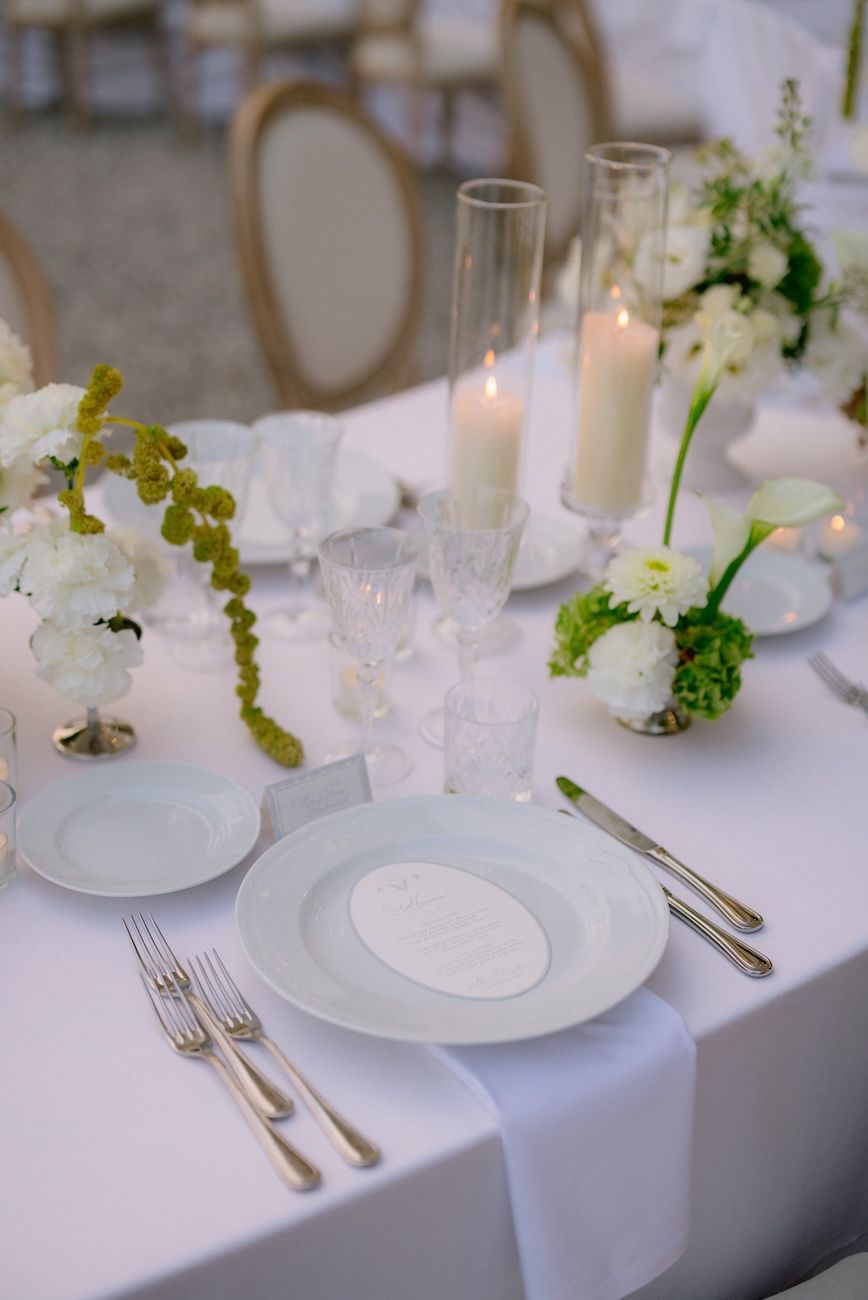 Wedding reception setup with white, pale pink and green flowers on semi circular tables. Design Solidea Events