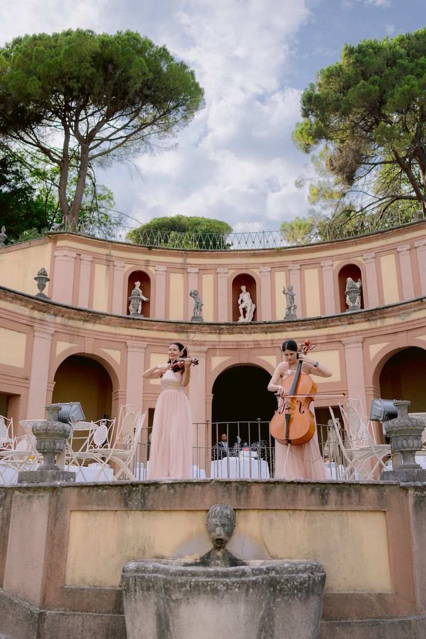 String duo playing in the monumental garden of Villa Bettoni. Lake Garda, Italy. Design Solidea Events