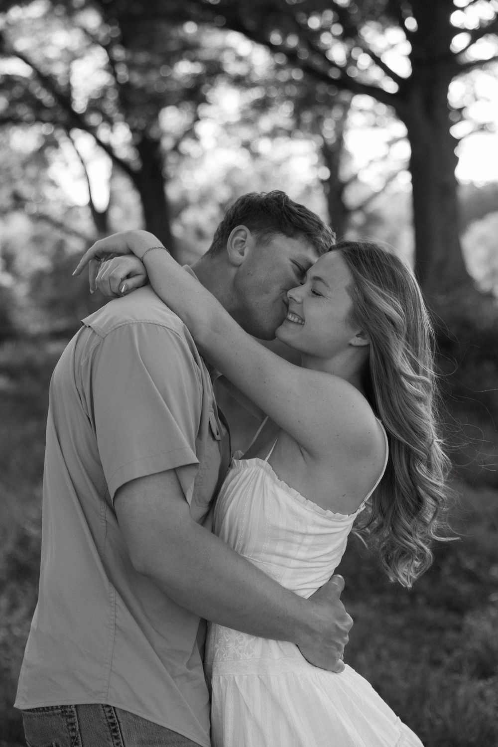 Black and white photo of a couple embracing in open fields during Atlanta engagement session.