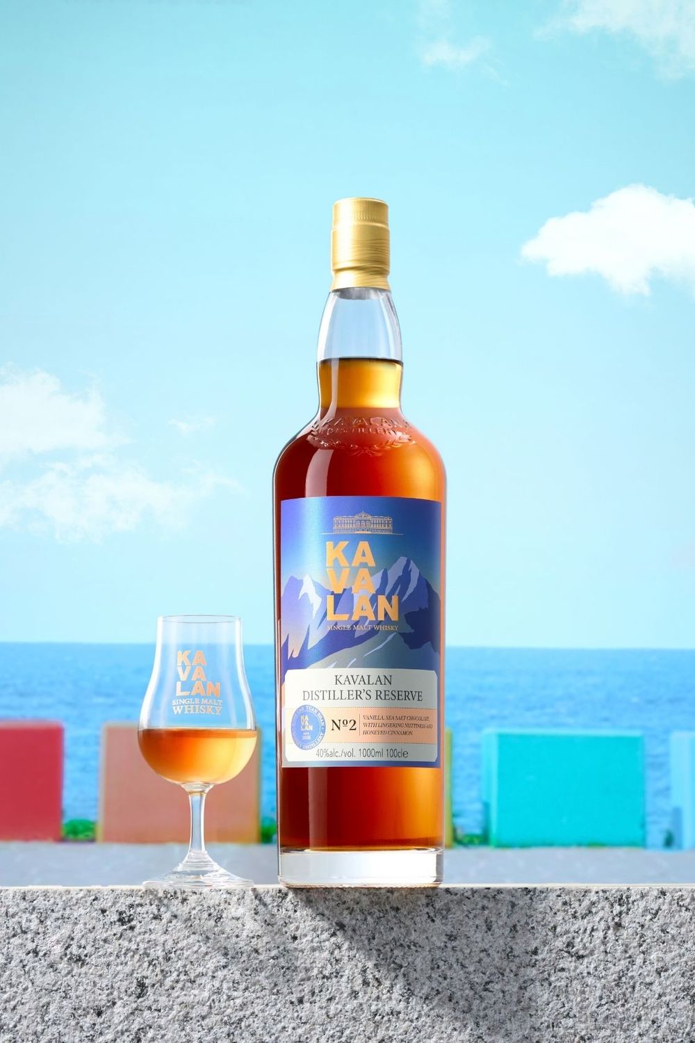 Kavalan Distiller's Reserve No.2 single malt whisky bottle with a glass, set against a vibrant ocean backdrop.