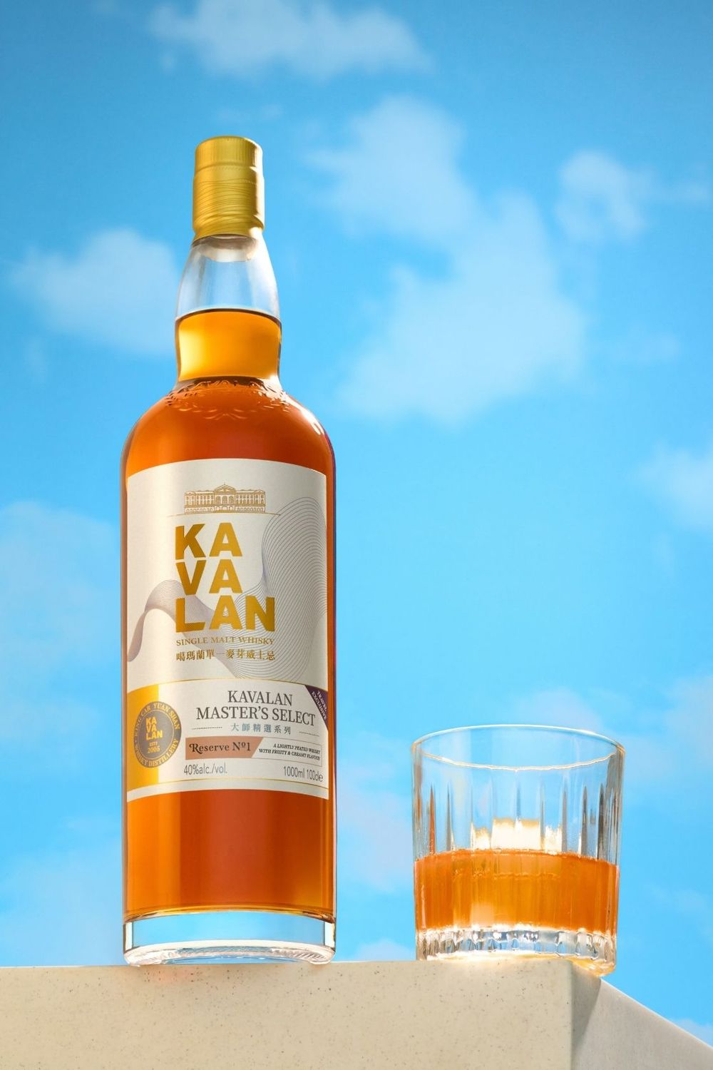 Kavalan Master's Select single malt whisky bottle beside a glass of amber whisky against a blue sky background.
