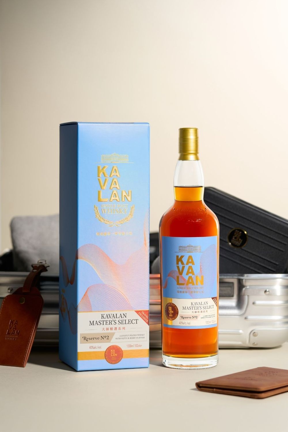 Kavalan Master's Select whisky bottle with blue gift box, leather wallet, and luggage tags on a white surface.
