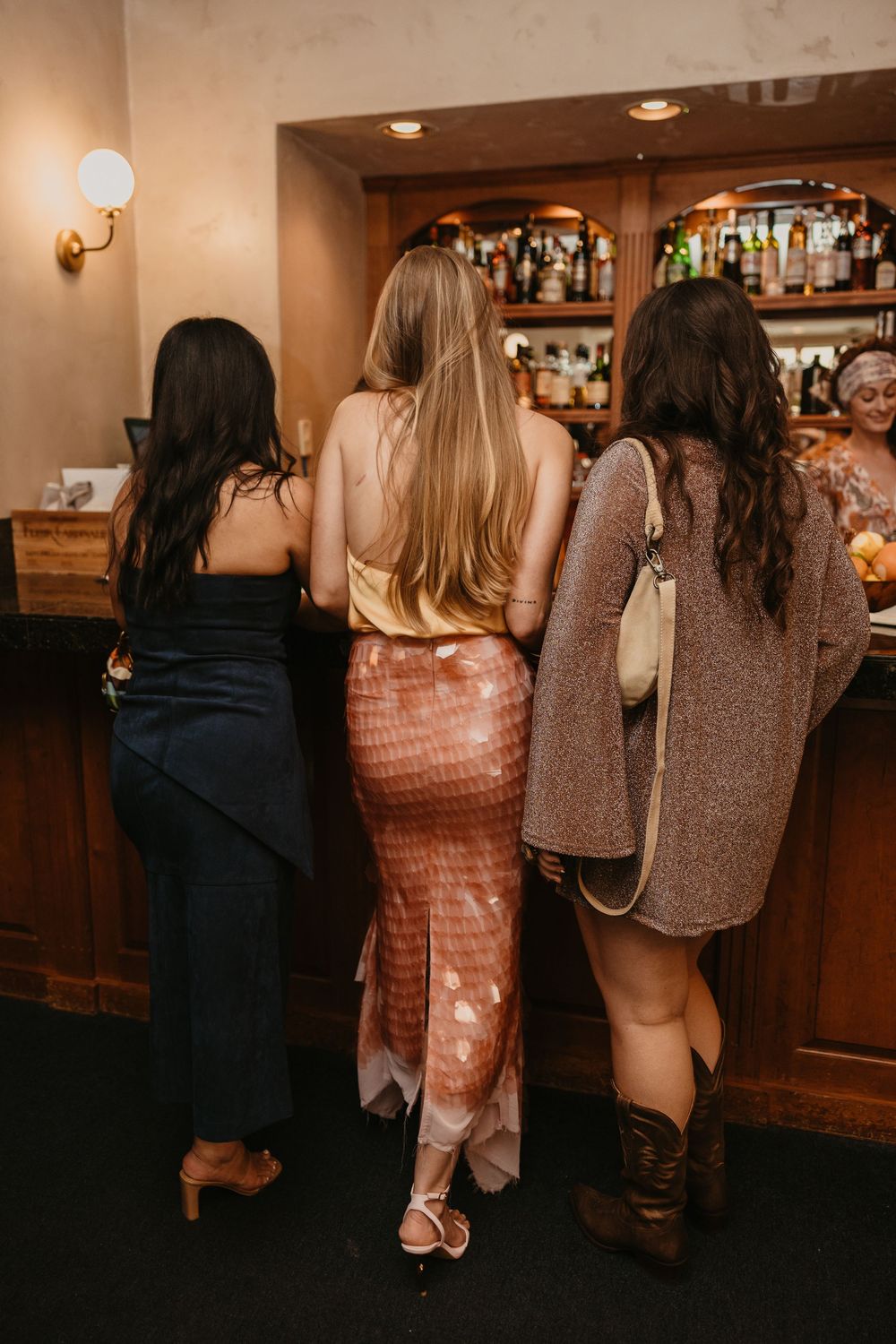 Gals getting a drink at Livingston, MT 2nd Street bistro on the night before a wedding at a welcome party captured by local Photographer
