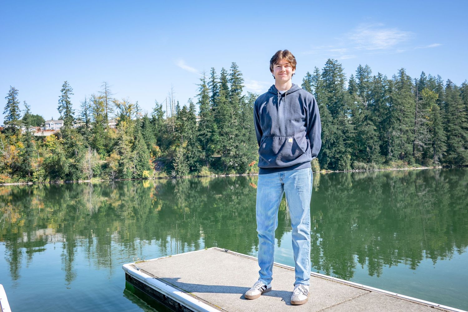 Full-length senior portrait on a dock overlooking Lake Wilderness in Maple Valley