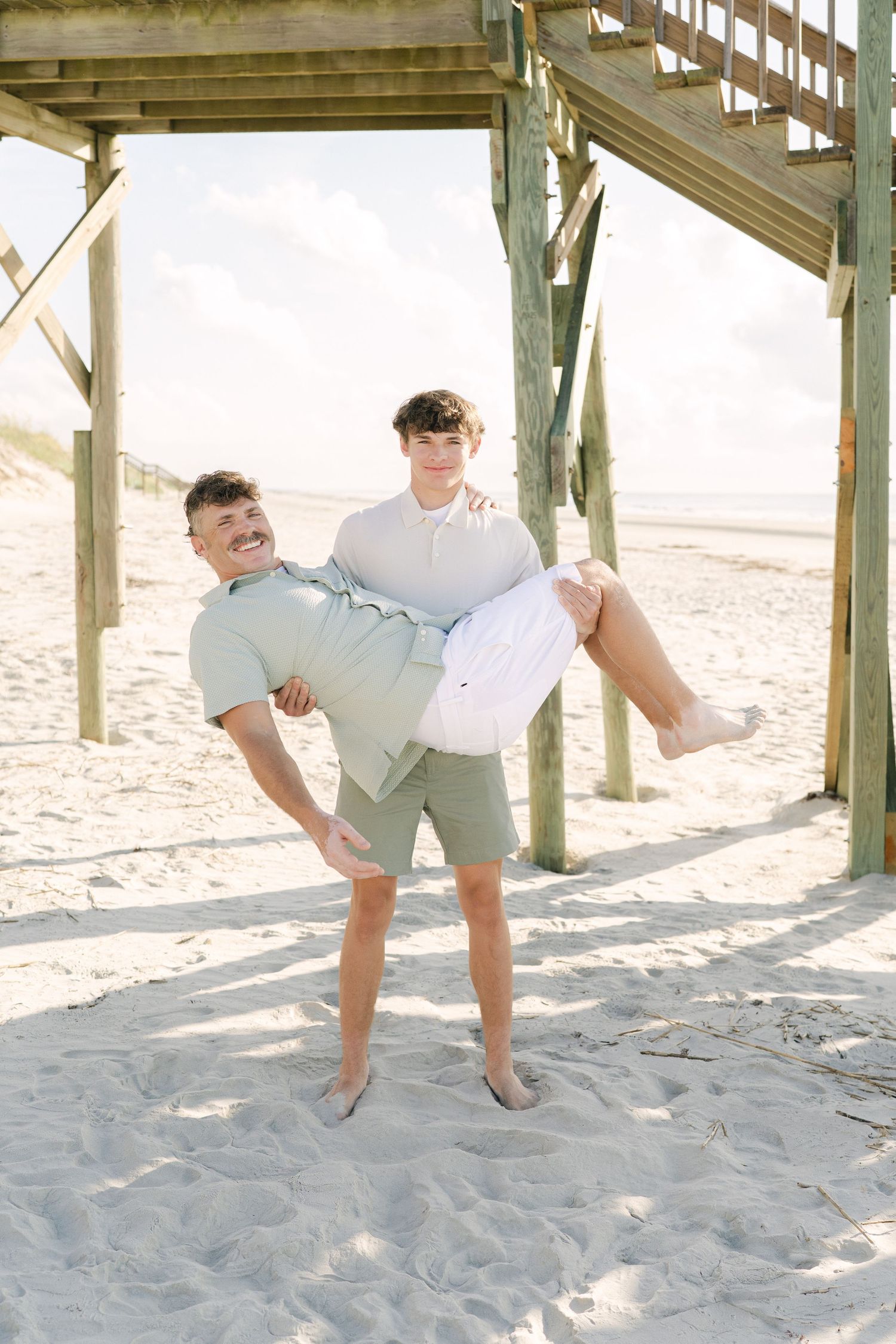 Father and teenage son photographed together on the beach in Georgia’s Golden Isles near Corsair Beach.