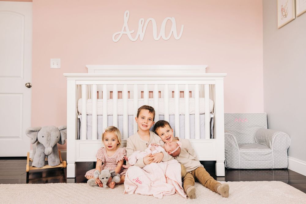 Pink nursery room with white crib and modern decor.