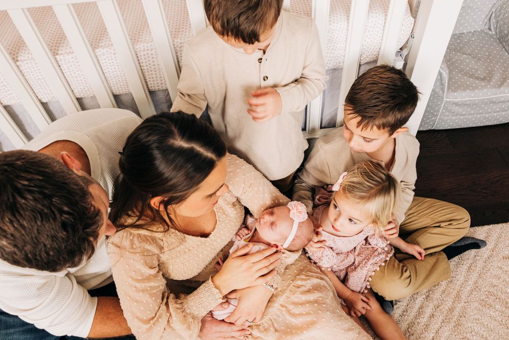Intimate family moment captured on white bedding in natural light.