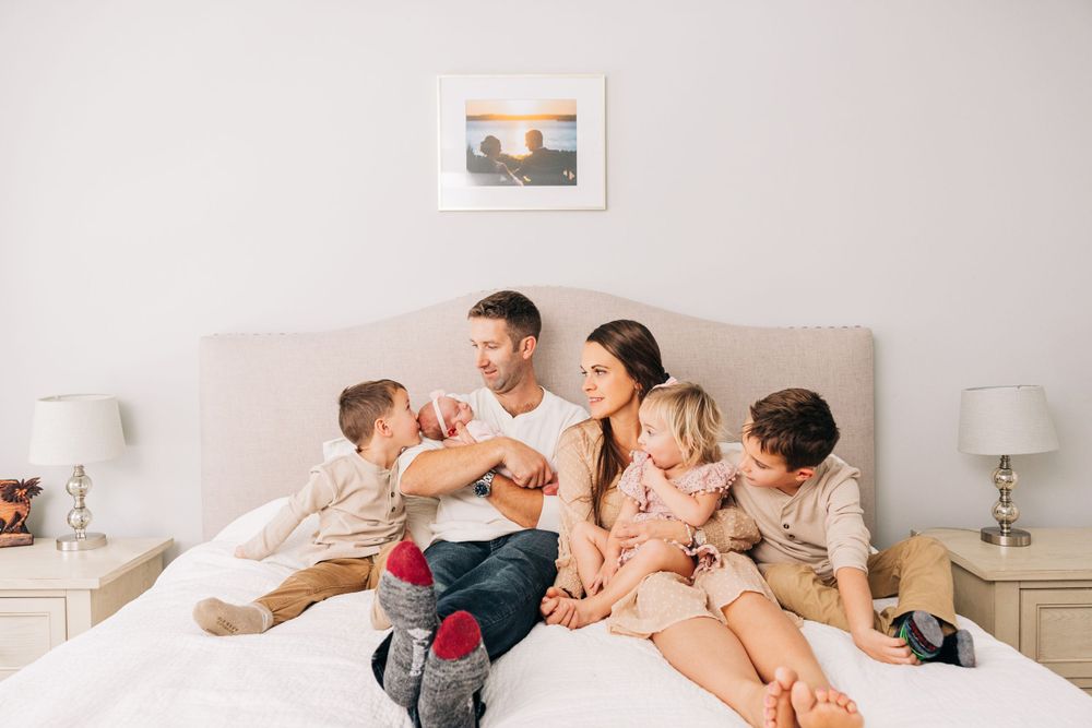 Family lifestyle session in a bright modern bedroom.