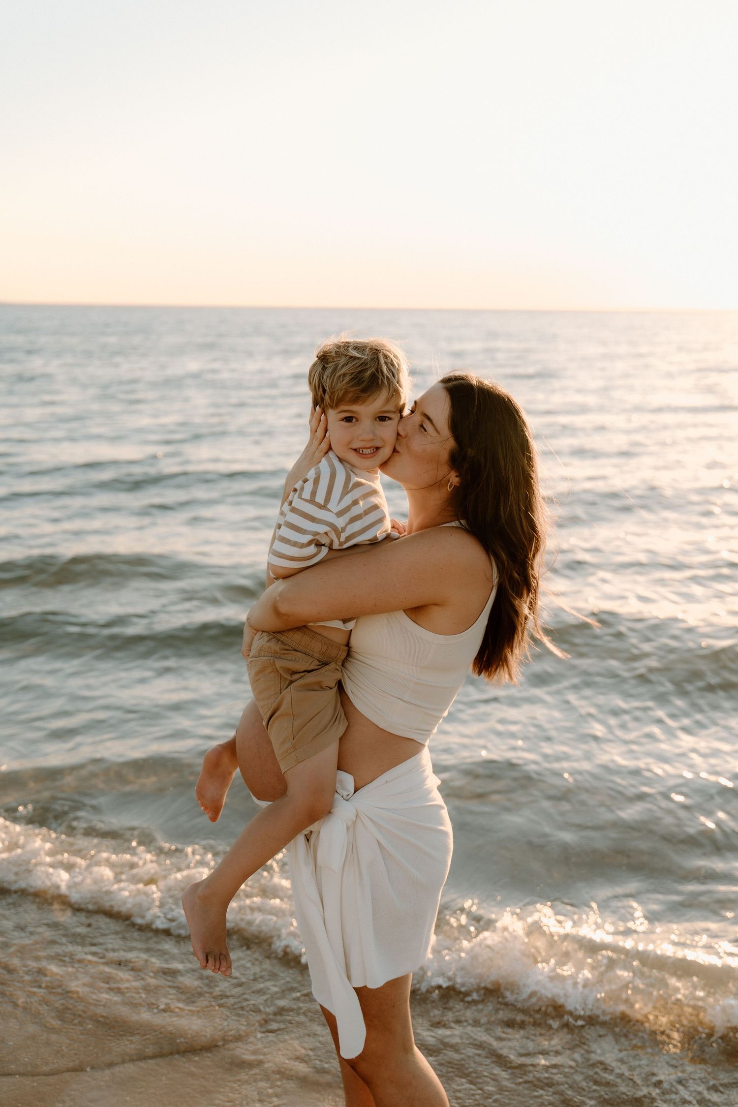 A candid family photo capturing a mother and son playing at a mornington peninsula beach