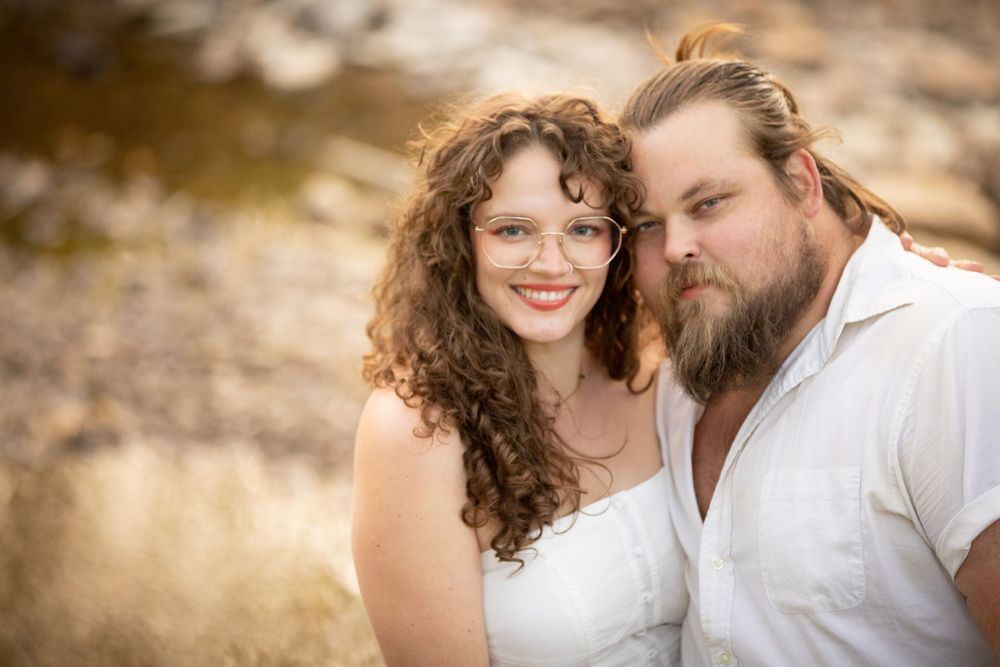 a couple poses together in matching white attire