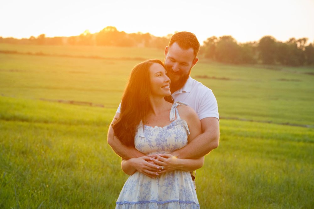 man and woman embracing at sunset in an Arkansas field