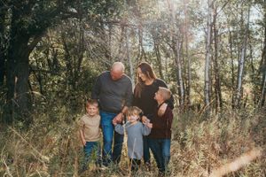 Family portrait in a wooded setting during golden hour.