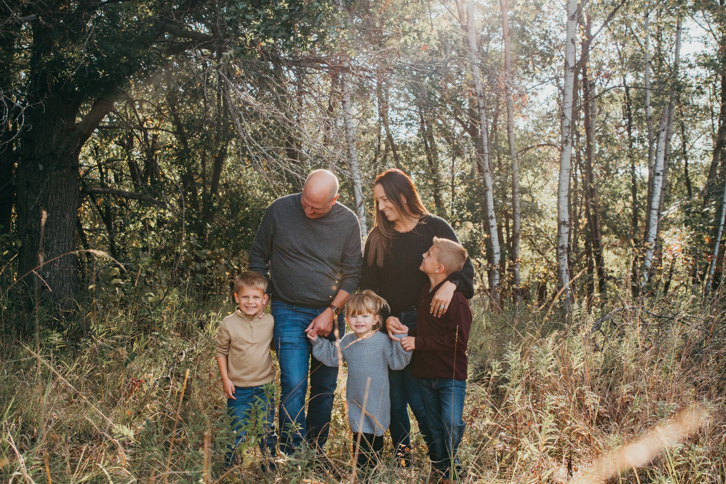 Family portrait in a wooded setting during golden hour.
