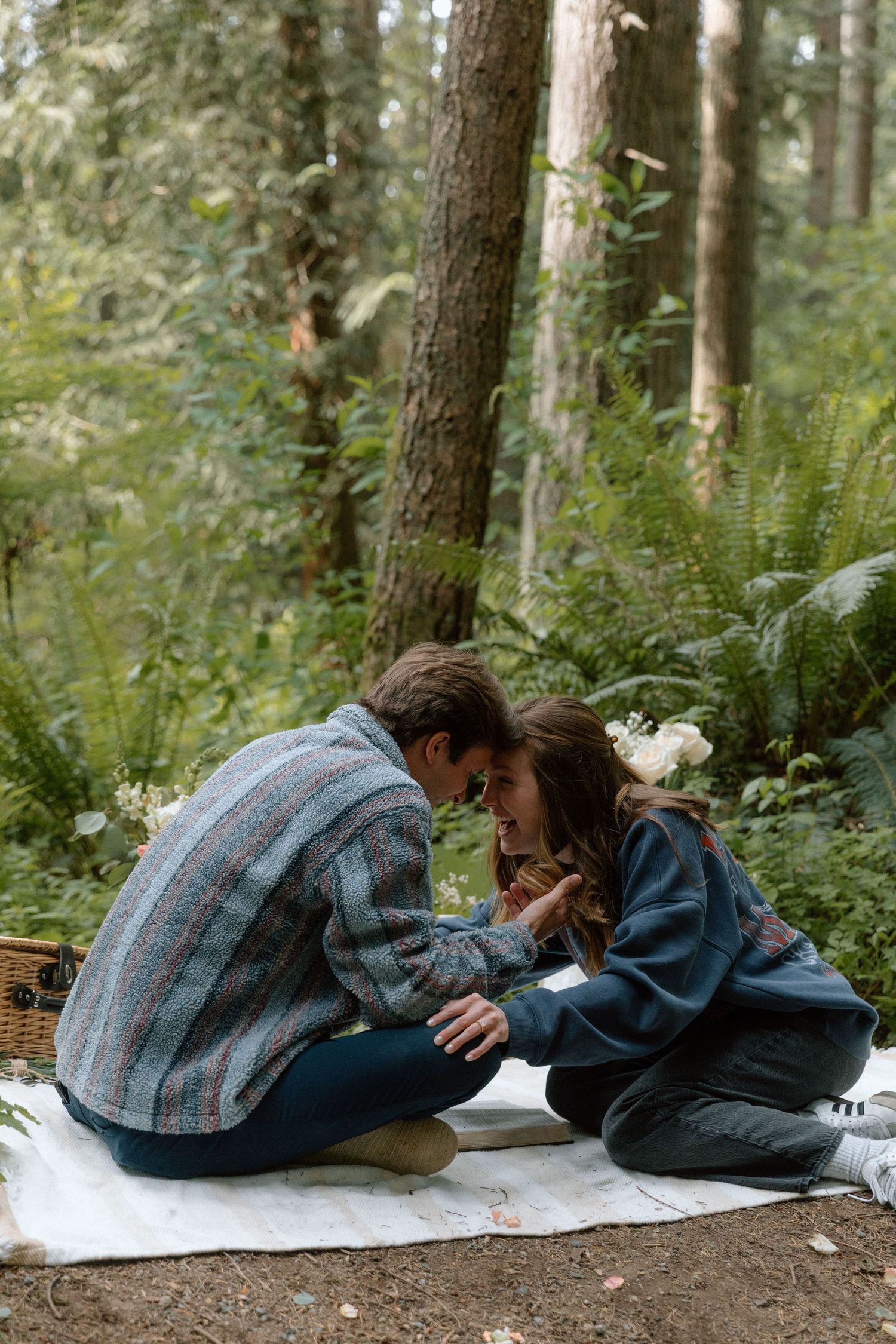 A series of four photos showing someone lying down on a white sheet in a wooded forest setting.