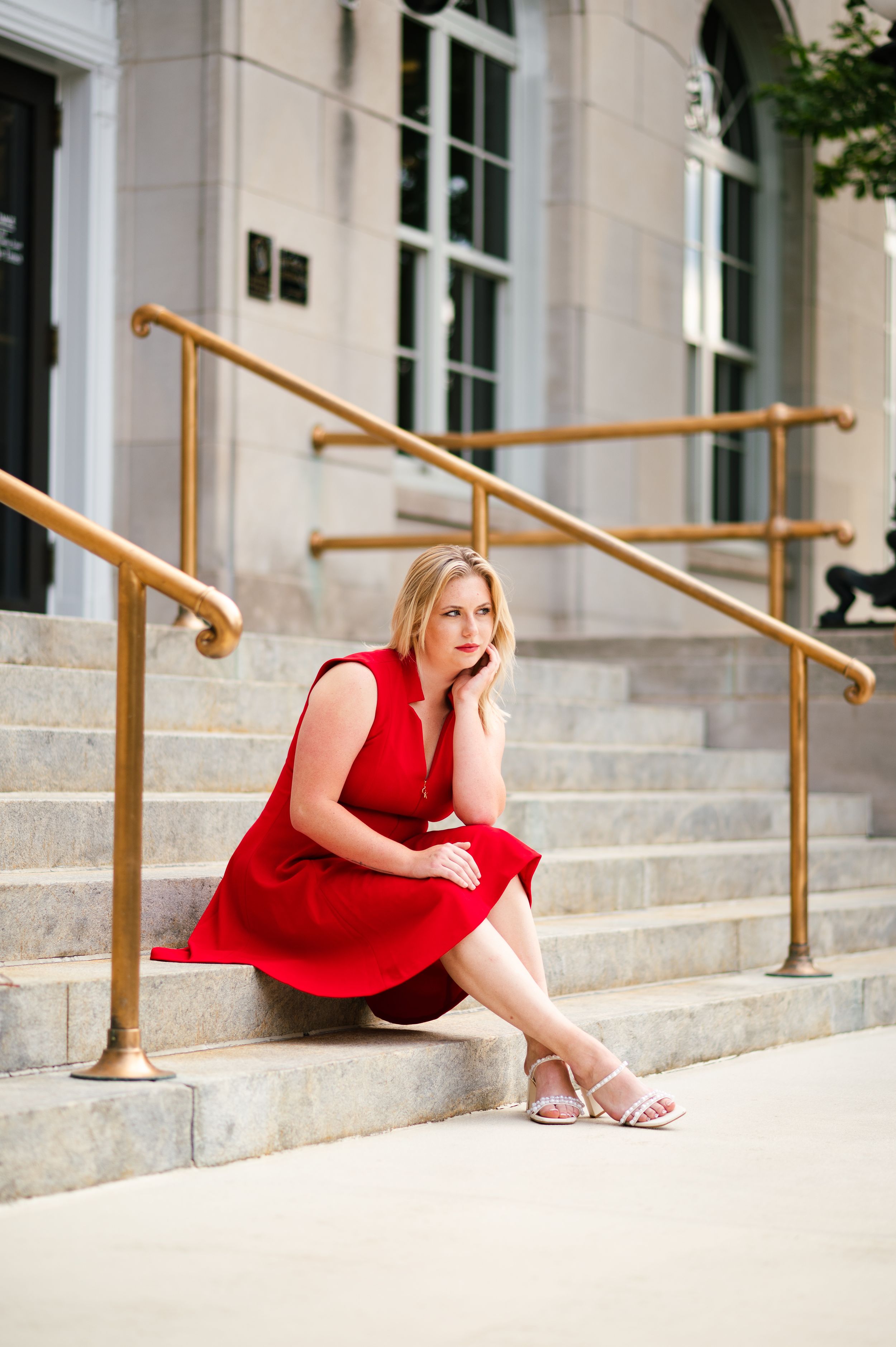 Women in a red dress sitting on steps in downtown Roanoke