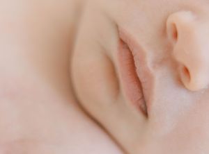 A close-up view of a sleeping baby's peaceful face with soft, delicate features and smooth skin.