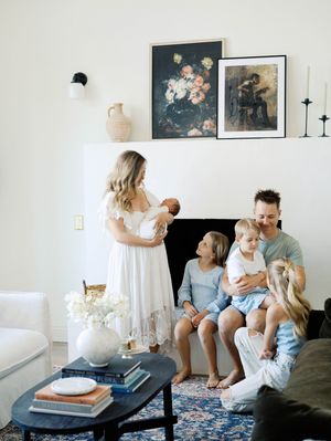 A series of tender family moments shared on a gray sofa in a bright living room with framed artwork on the walls.