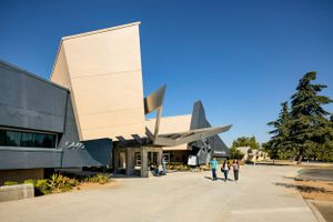Modernist building exterior with sharp angular facades and walkways under bright blue sky.