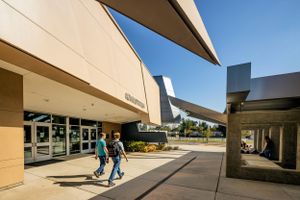 Modern building exterior with dramatic angular overhangs creating covered pathways.