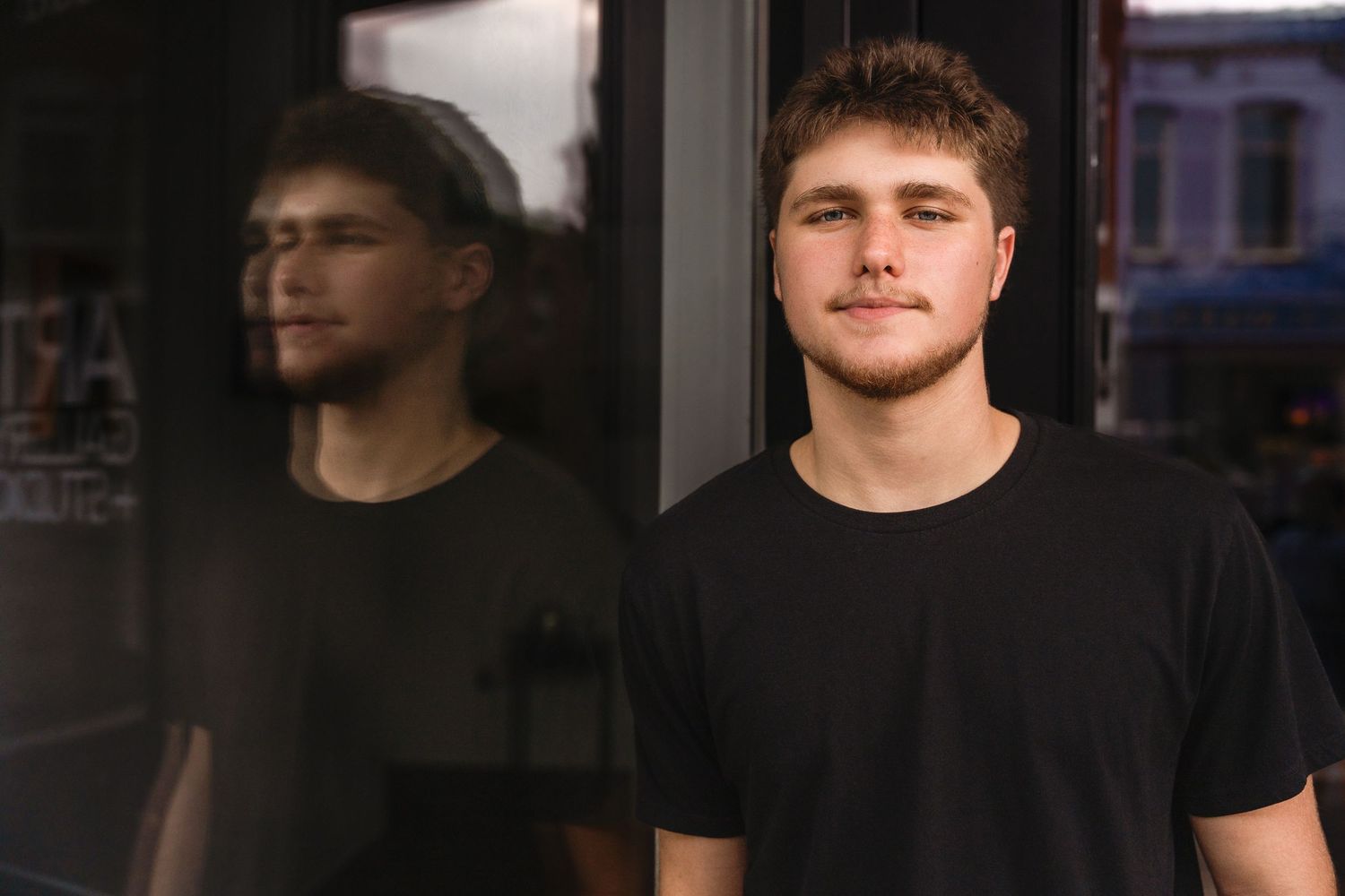 A series of similar headshots showing a person in a black t-shirt against dark backgrounds.